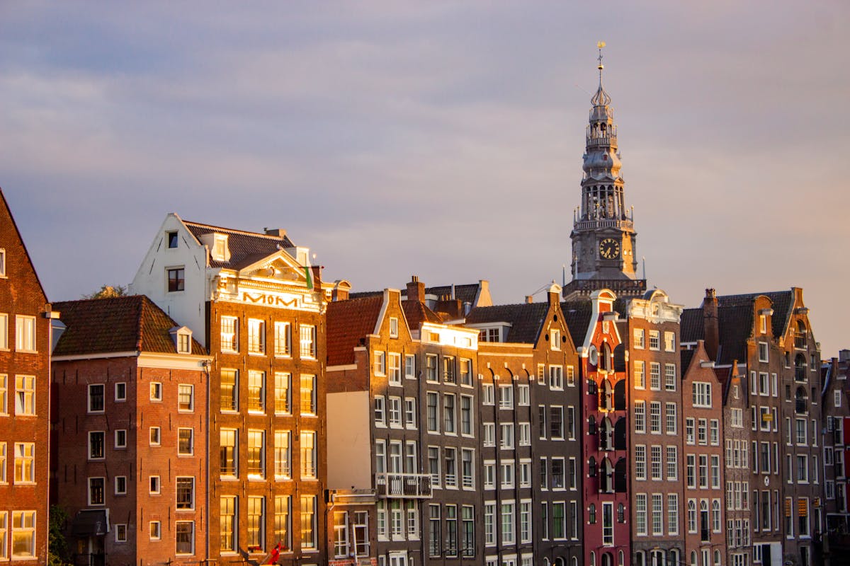 A picturesque view of traditional houses along Amsterdam canal at sunset