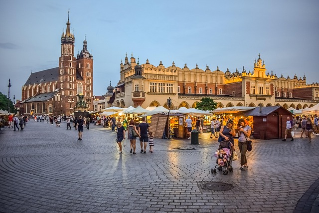 Krakow main town square at evening dusk with illuminated church and buildings