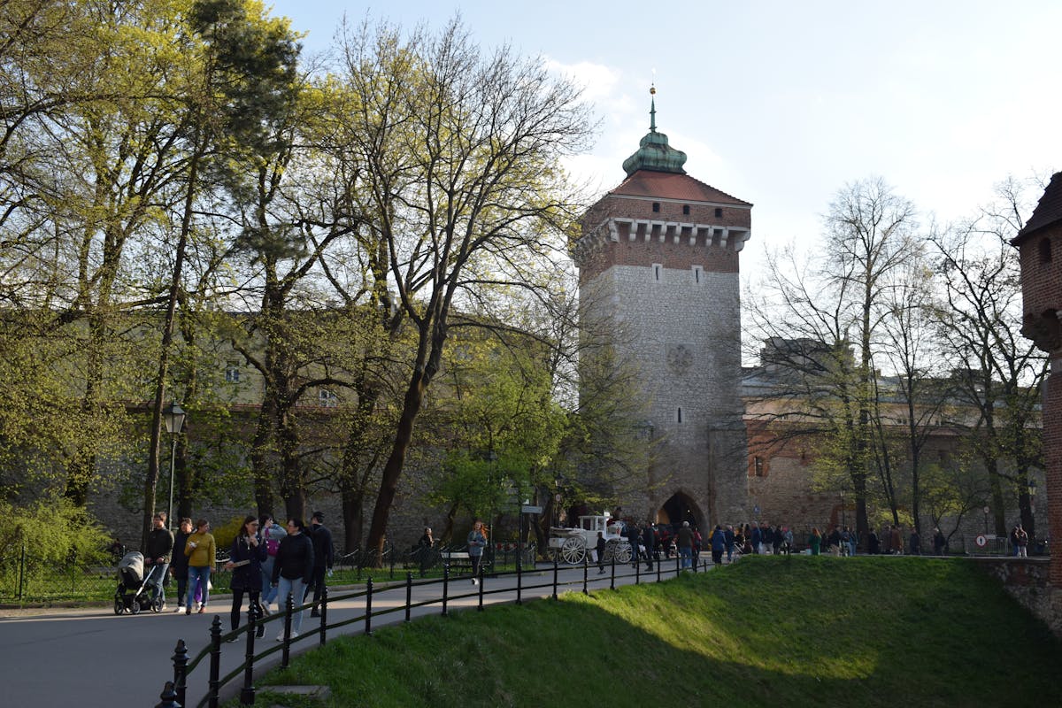 Historic Krakow city wall and tower with people walking in spring