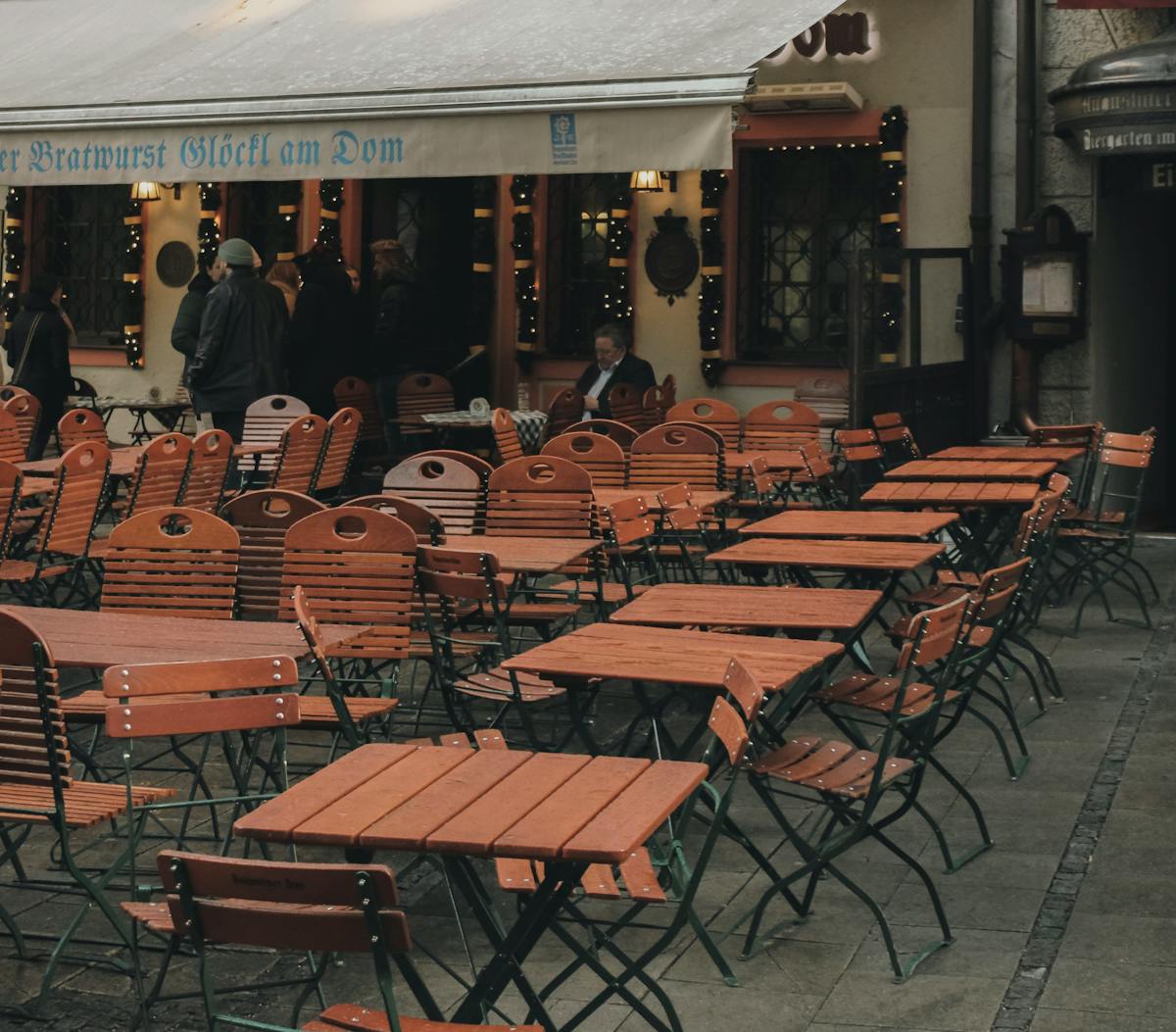 Cozy outdoor seating area of a traditional Munich cafe with wooden chairs