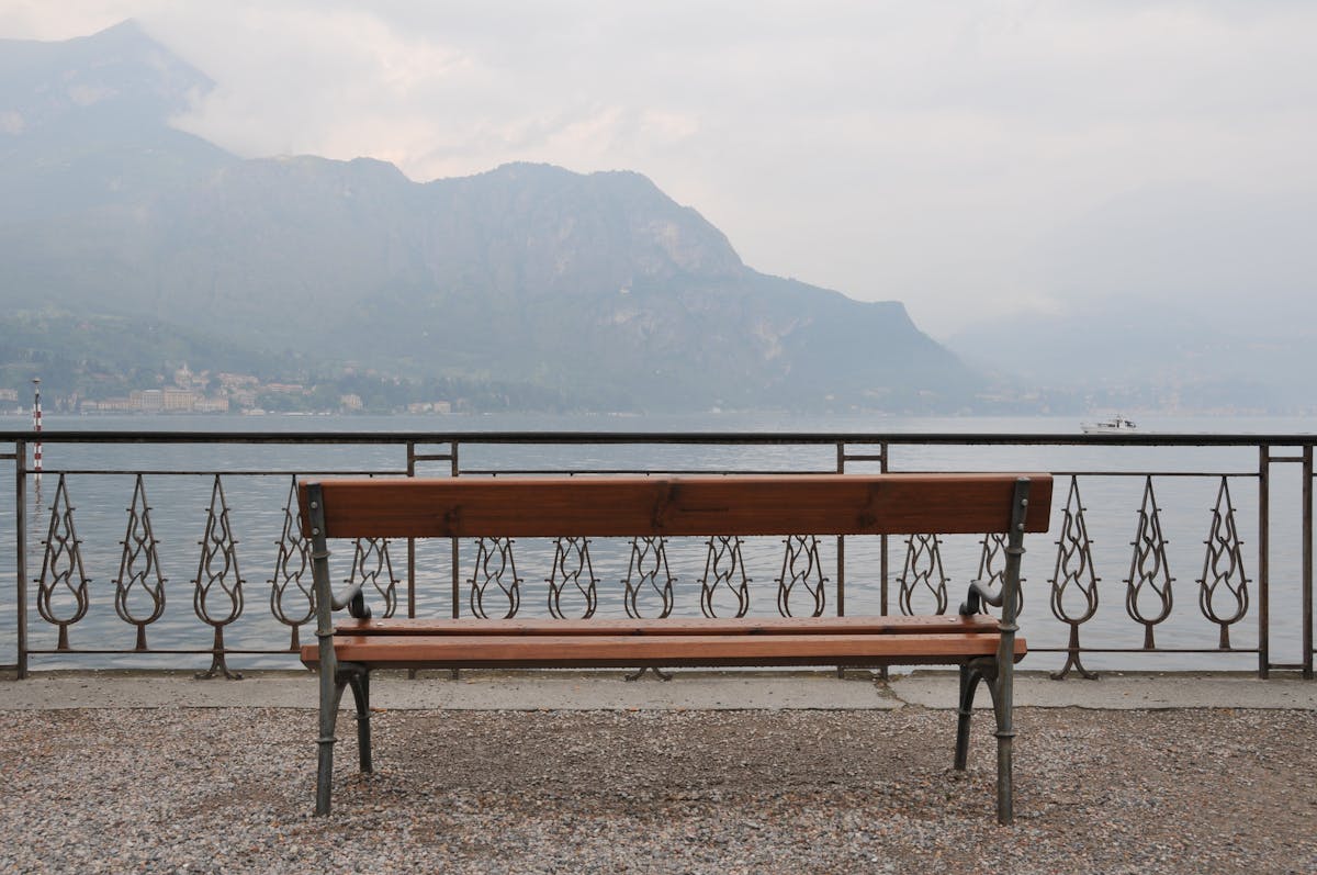View of Lake Como from a bench in Bellagio with mountains in the background