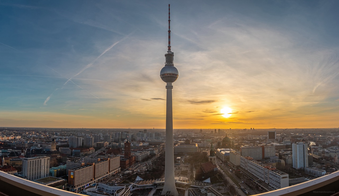 The Berlin Fernsehturm silhouetted against a vivid sunset sky