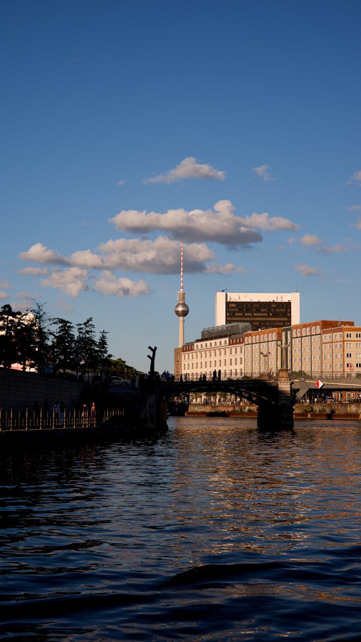 Berlin TV Tower at sunset with warm light reflecting across the Spree River