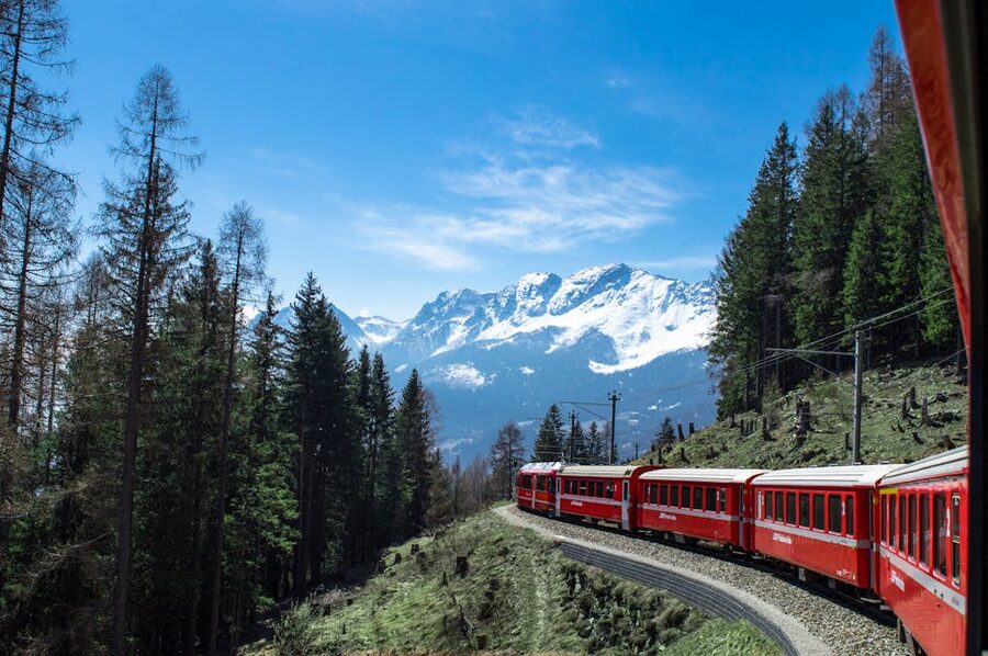 Bernina Express through lush forests and snowy mountains