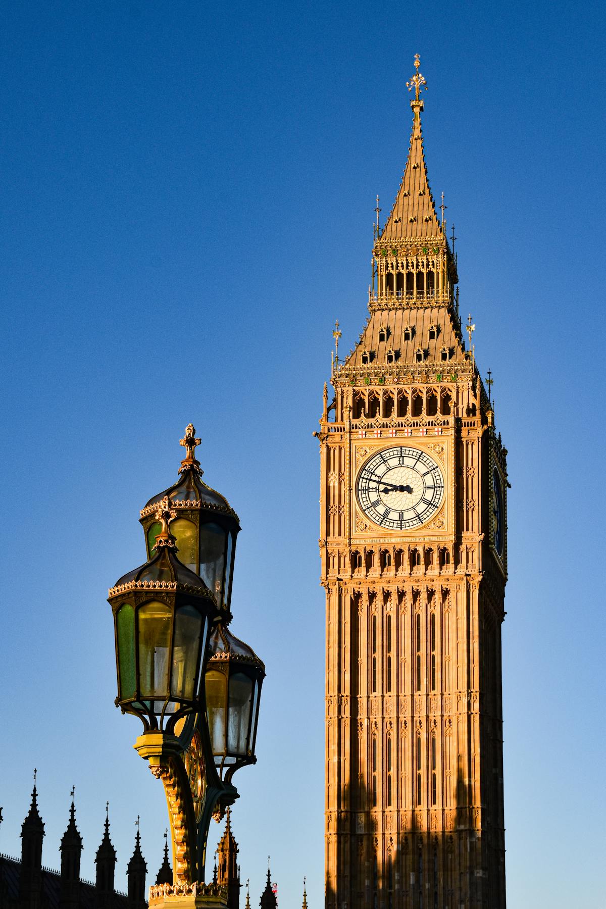 Big Ben and ornate Westminster street lamps against a clear sky