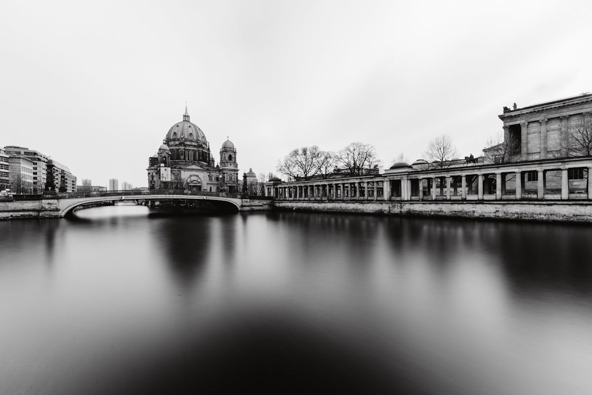 Black and white view of the Berlin Cathedral from the River Spree with a bridge