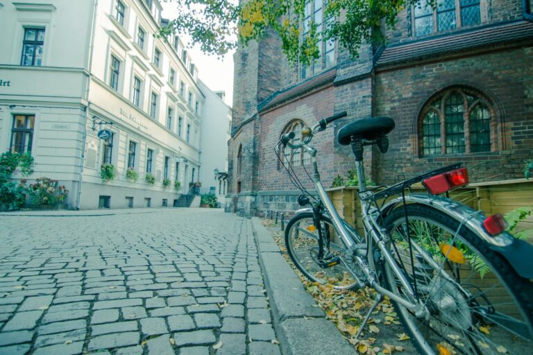 A bicycle parked against a historic building on a cobblestone street in Berlin