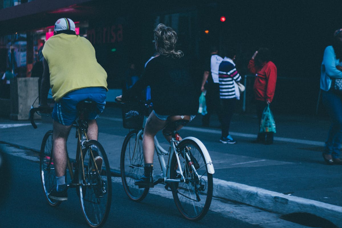 Two cyclists biking on an urban street