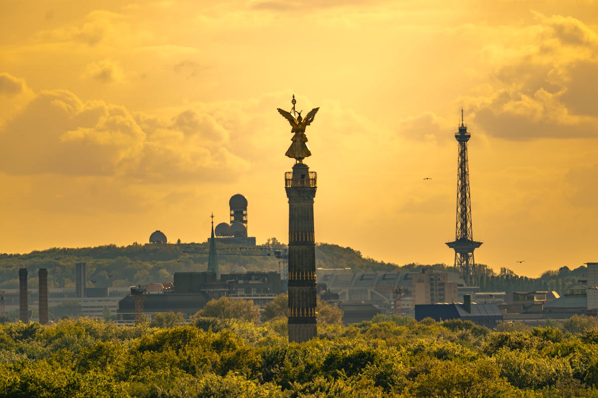 The Victory Column in Berlin at sunset with lush greenery in the foreground