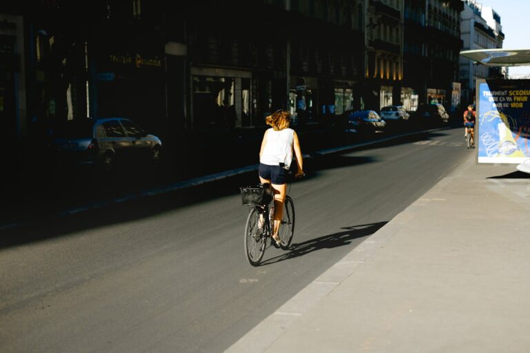 Woman cycling through a Paris street with classic architecture
