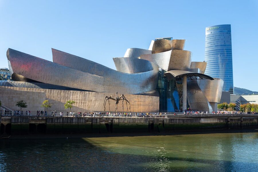 Guggenheim Museum Bilbao reflected in the Nervion River under a clear sky