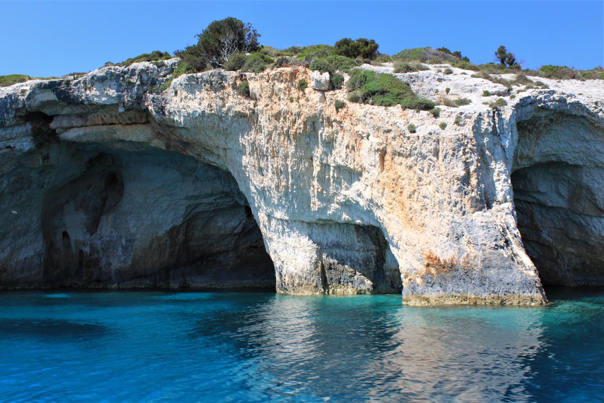Turquoise waters and rocky formations inside a blue cave in Greece