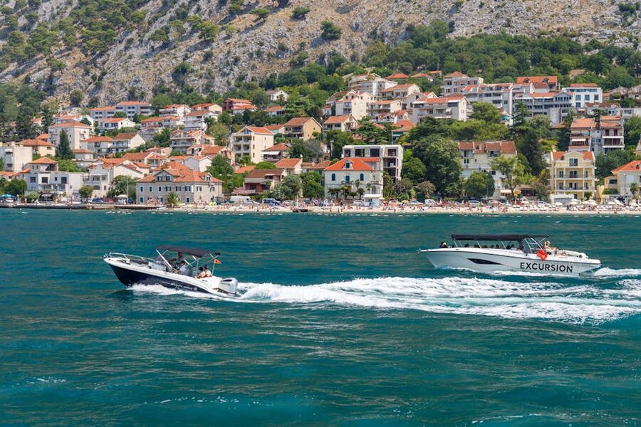 Two boats cruising along Adriatic coast near coastal town