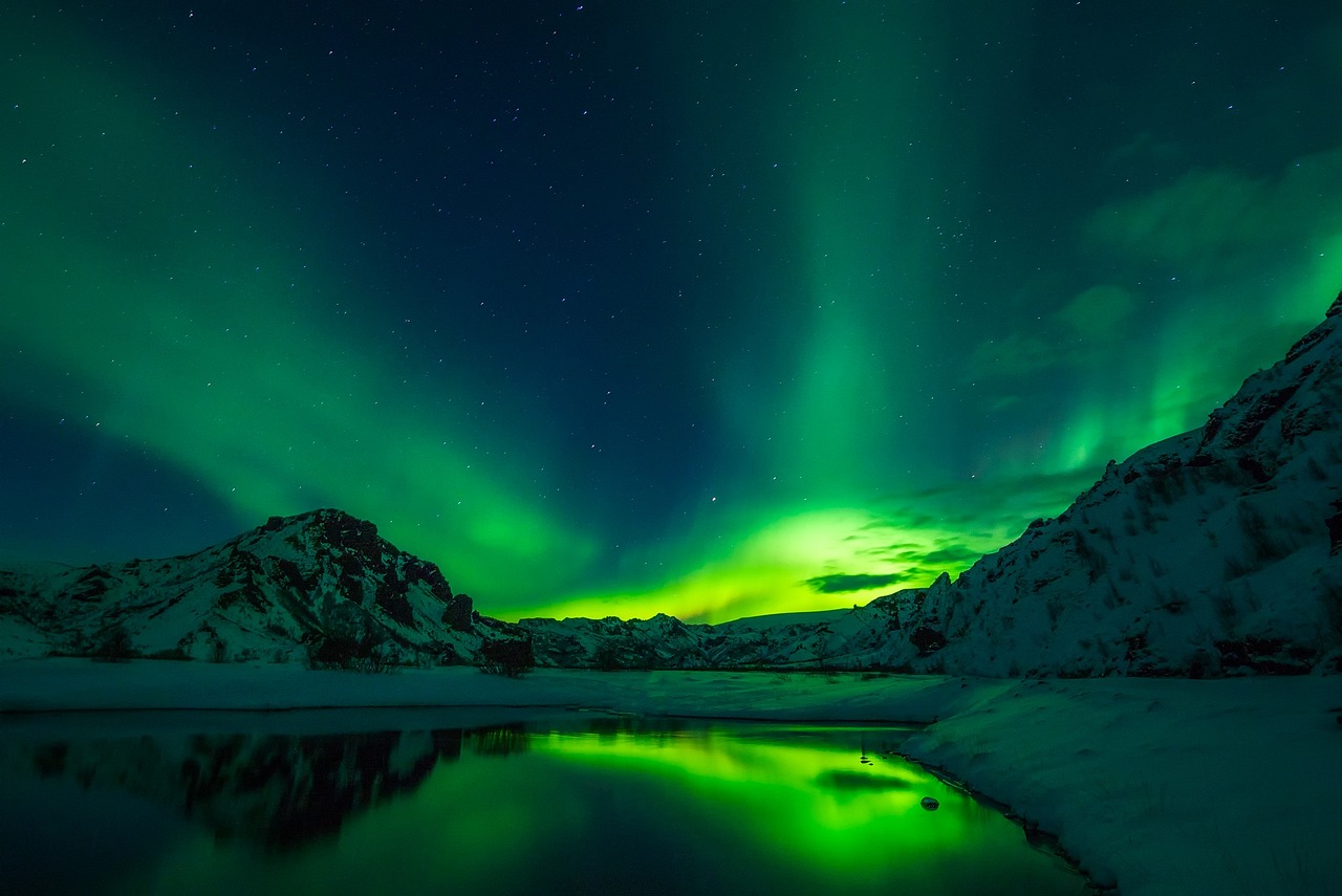 Aurora borealis glowing green over an Icelandic winter landscape