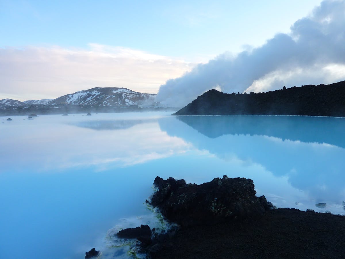 Steam rising from the Blue Lagoon with mountains in the background in Iceland