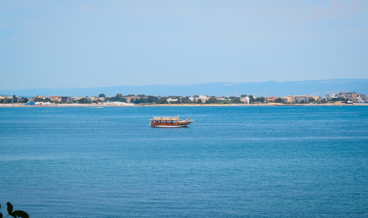 A boat floating near the sandy coast of Sardinia with turquoise water