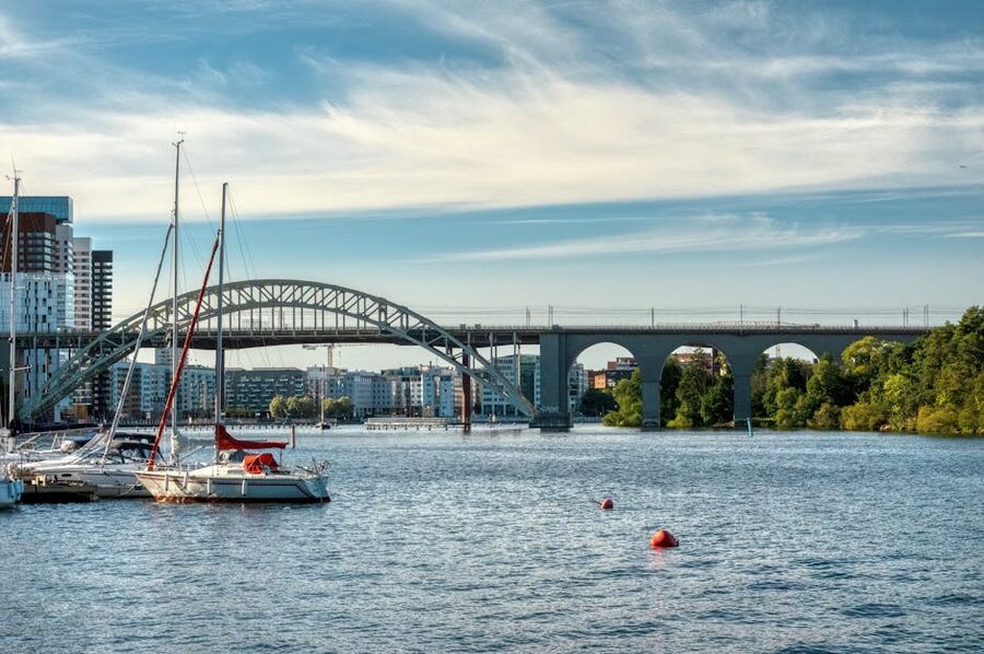 Sailboats passing under a bridge in Stockholm