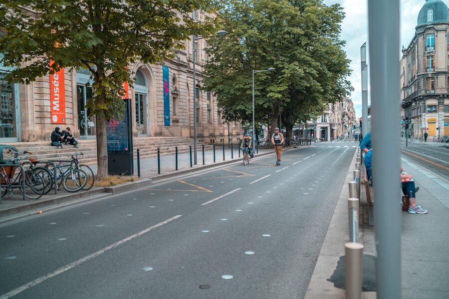People biking and walking on a wide Bordeaux street