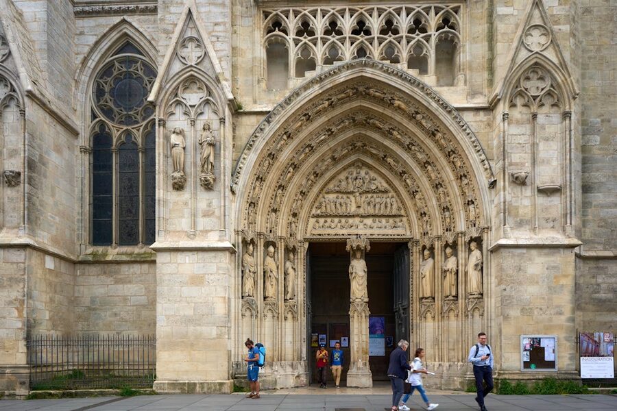 Gothic architecture of Bordeaux Cathedral with visitors at entrance