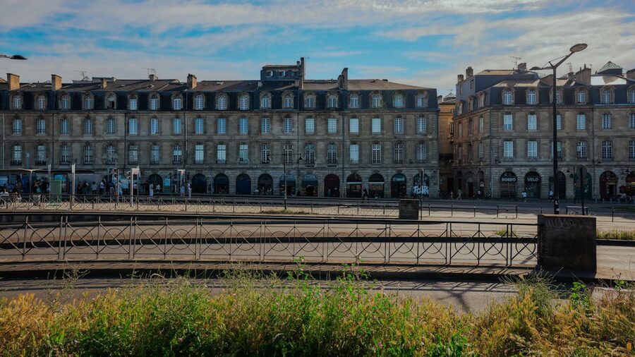 Elegant historic limestone buildings in Bordeaux under blue sky