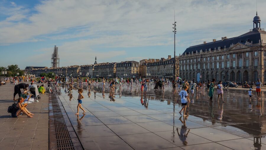 Families enjoying the Miroir d'eau reflecting pool at Place de la Bourse Bordeaux