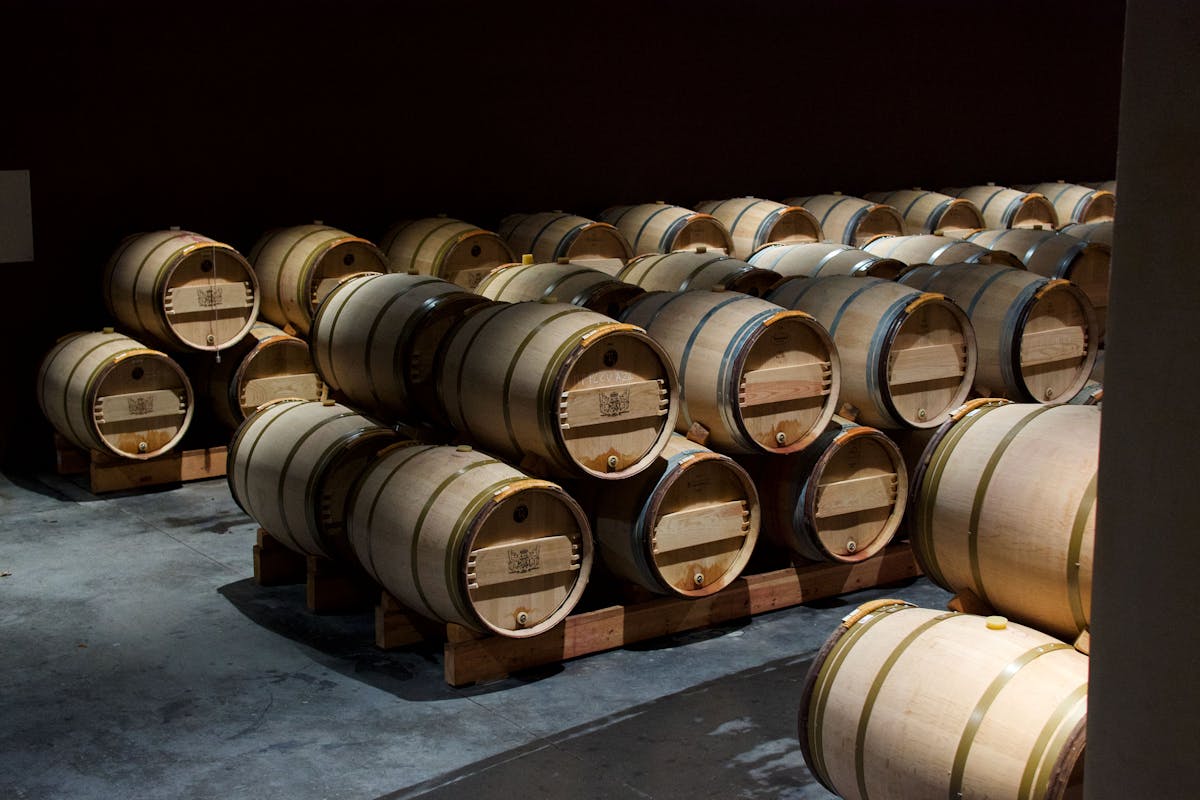 Oak wine barrels in a dimly lit French wine cellar