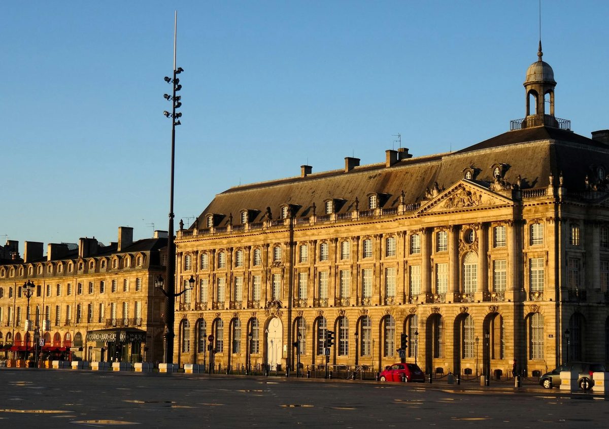 Elegant stone building in Bordeaux city center lit by golden sunset light
