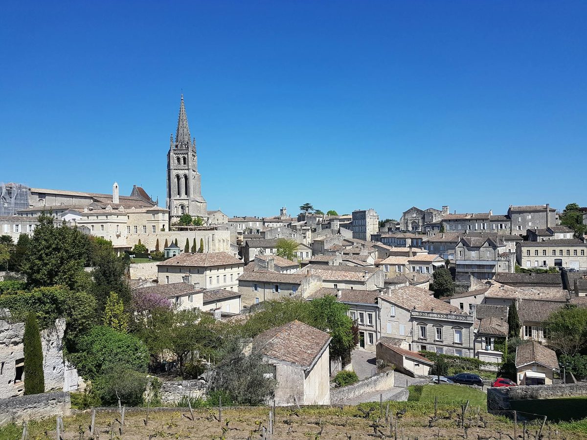 The monolithic church bell tower rising above medieval stone buildings in Saint-Emilion