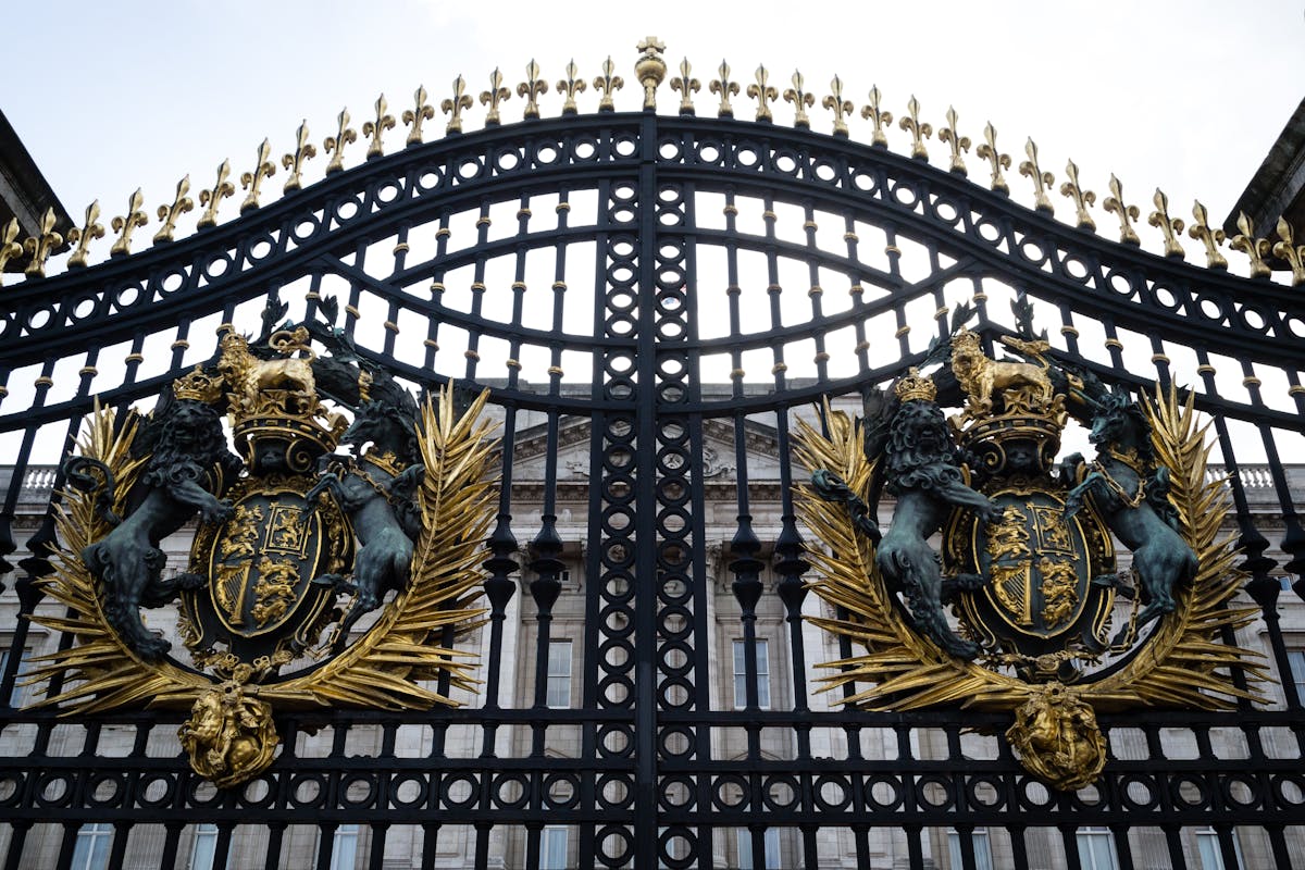 Ornate gate featuring the royal coat of arms at Buckingham Palace London