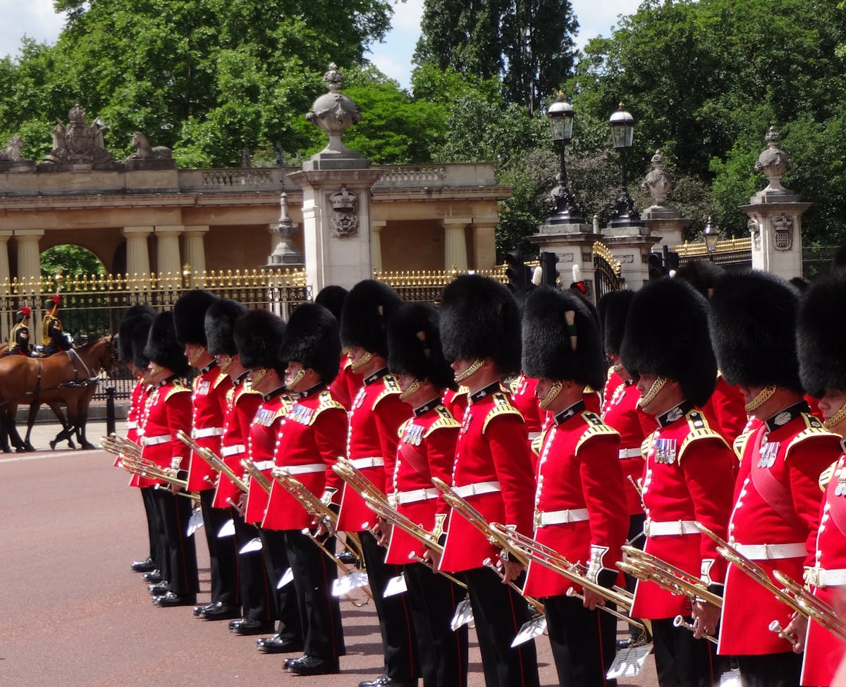 Line of British guards in red tunics and bearskin hats at Buckingham Palace