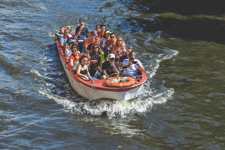 Bruges canal cruise boat with tourists in old town