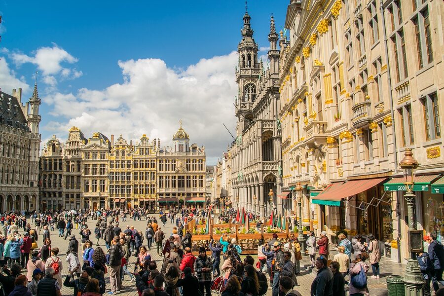 Tourists in Brussels Grand Place admiring buildings