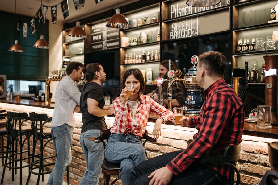 Casual group of friends drinking beer at a bar counter on a pub crawl