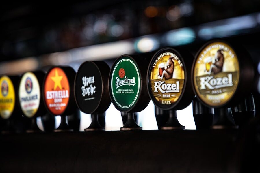 Beer taps featuring diverse brand logos on a Brussels bar counter