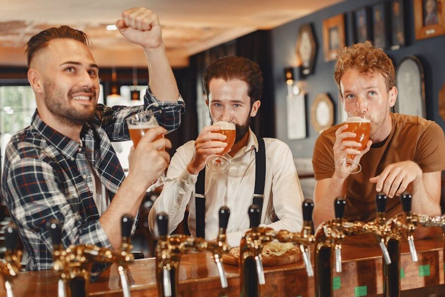 Three friends enjoying craft beer together at a pub