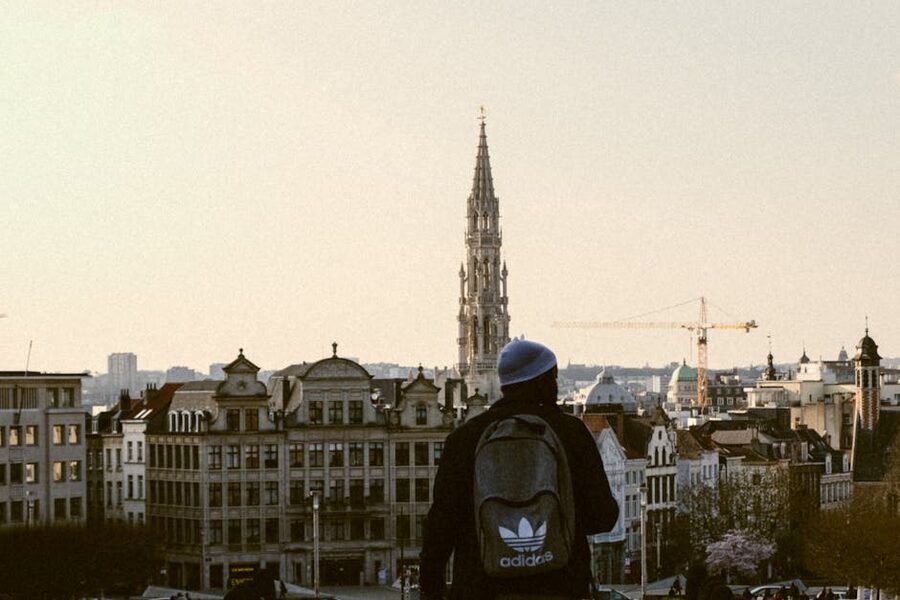 Independent traveler with backpack overlooking Brussels skyline