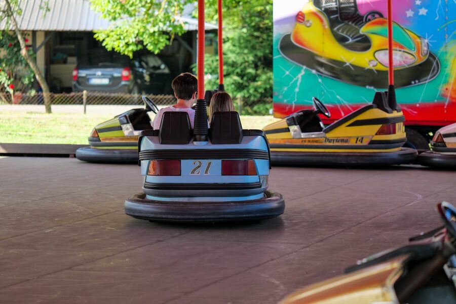 Kids driving bumper cars at an outdoor fairground attraction