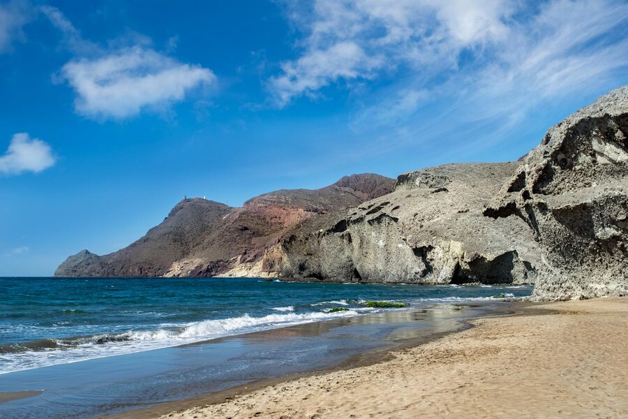 Pristine sandy beach framed by rugged cliffs at Cabo de Gata Natural Park