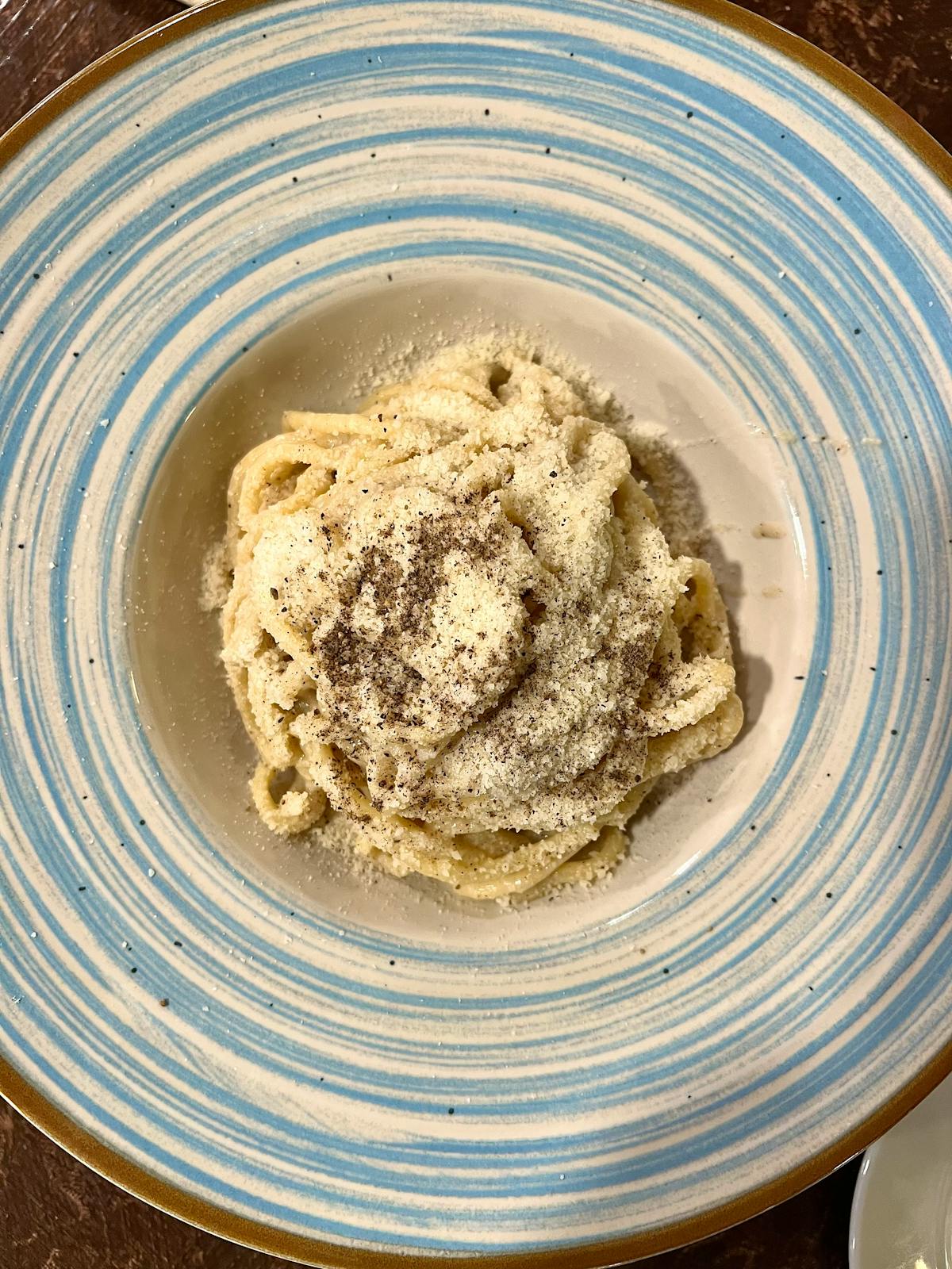 Plate of cacio e pepe pasta with creamy pecorino and black pepper