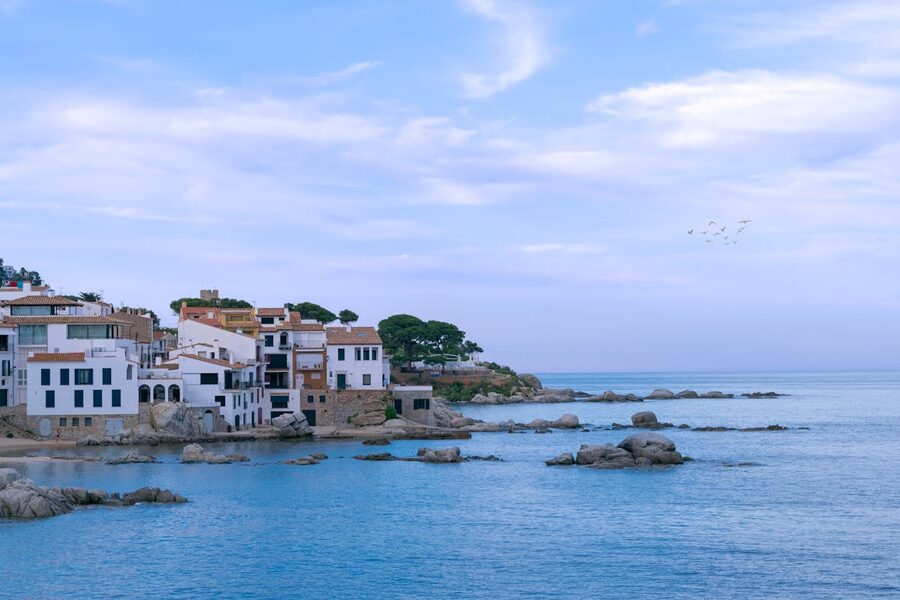 The charming fishing village of Calella de Palafrugell with white houses hugging the Costa Brava shoreline