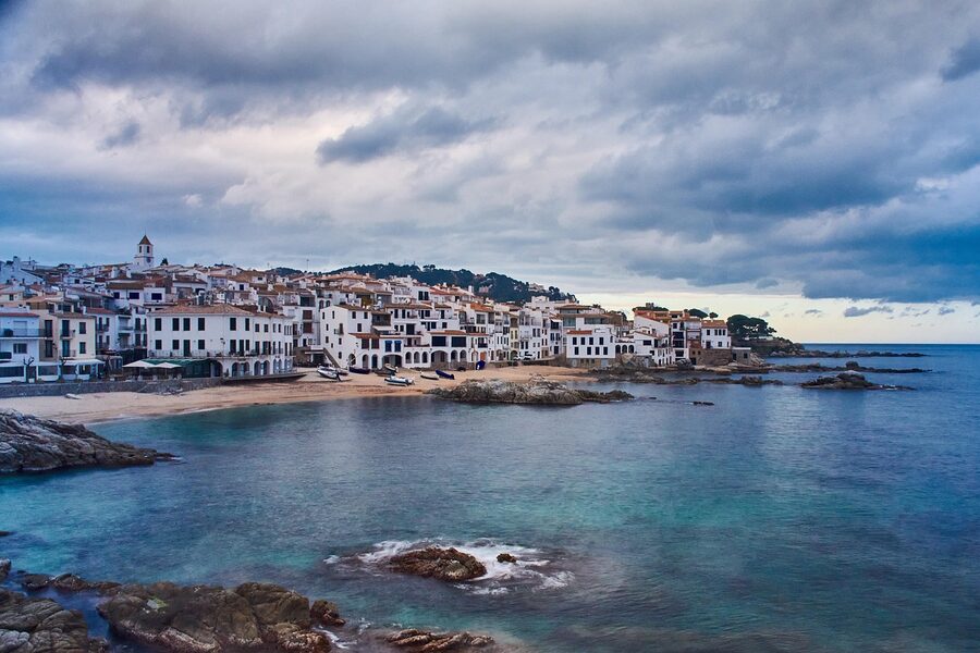 Seaside town of Calella de Palafrugell on the Costa Brava with boats and clouds