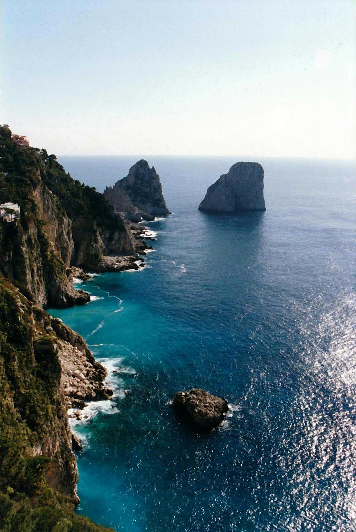 The towering Faraglioni rock formations rising from the blue Mediterranean sea at Capri