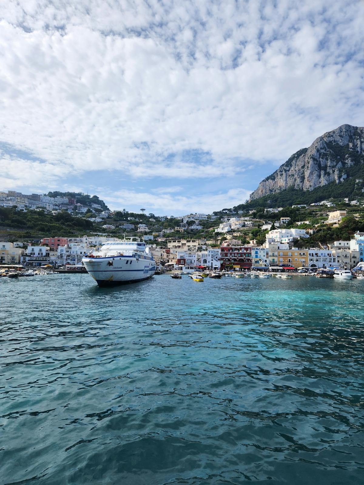Boats moored at Marina Grande harbor in Capri with coastal buildings in the background