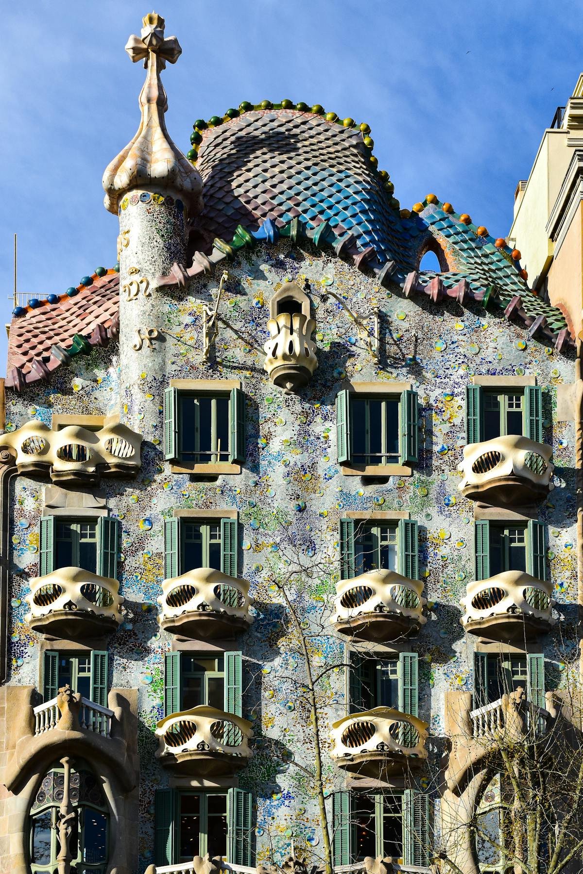 The colourful facade of Casa Batllo on Passeig de Gracia in Barcelona showing Gaudi distinctive bone-like columns and shimmering mosaic tiles
