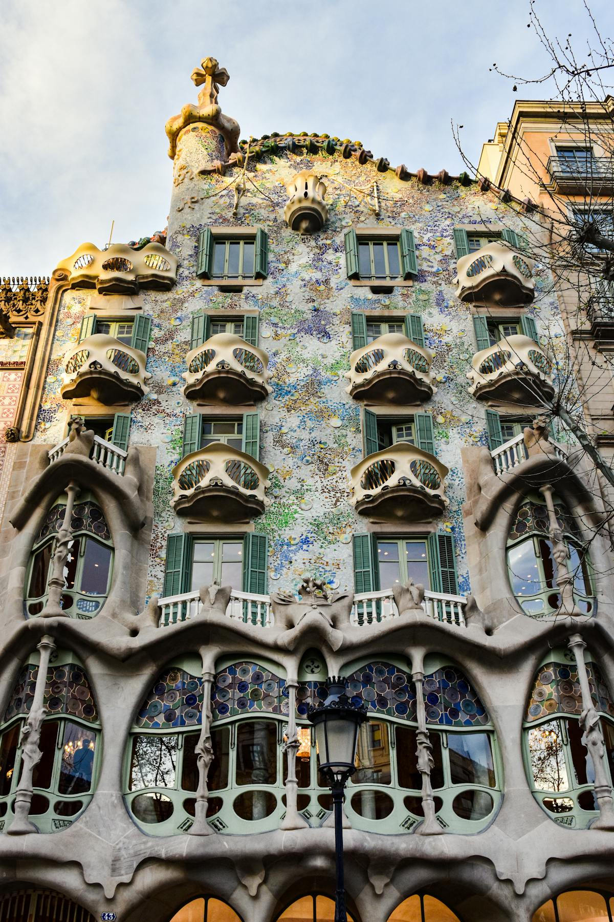 Close-up of Casa Batllo facade showing the organic curves and coloured glass disc mosaics designed by Gaudi