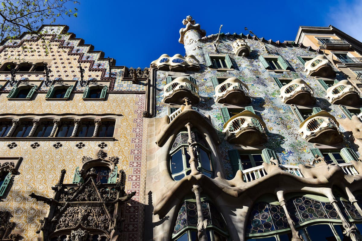 Wide view of the Casa Batllo facade showing the full building front with its skull-like balconies and shimmering tile work