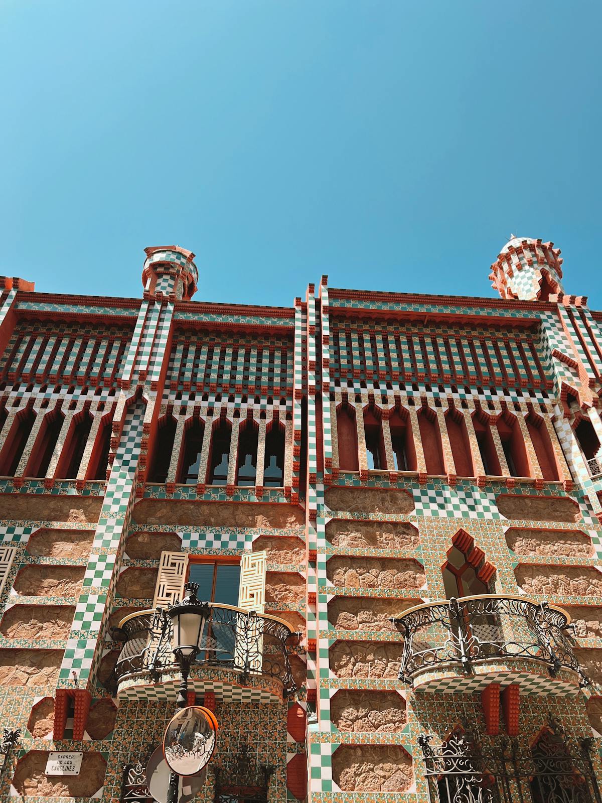 Casa Vicens facade under clear Barcelona sky showing the full checkerboard tile pattern