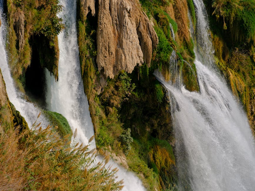 Cascading waterfalls surrounded by lush greenery and rock formations