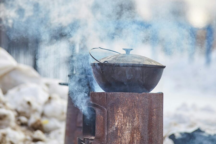 Cast iron stew pot over an outdoor fire