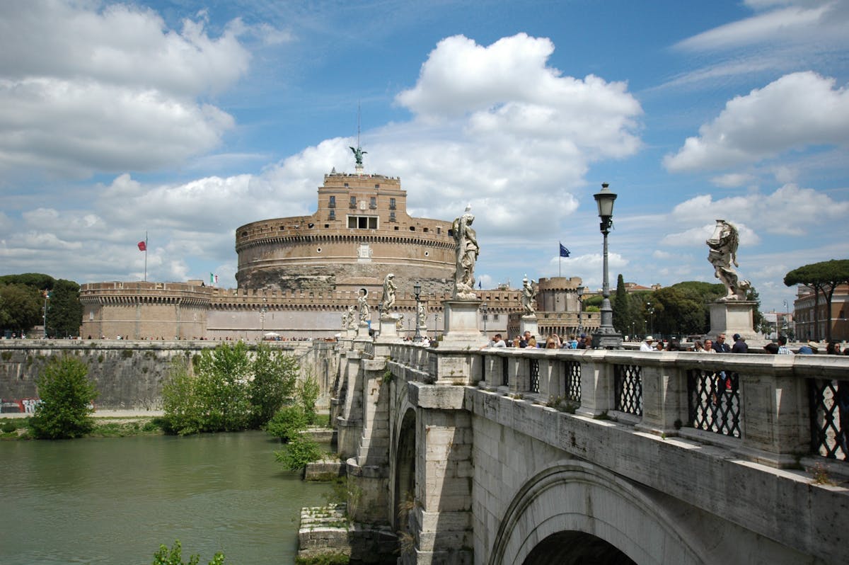 Ponte Sant'Angelo leading to Castel Sant'Angelo under dramatic skies in Rome